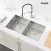 Brushed nickel undermount double-bowl kitchen sink installed beneath a white stone countertop