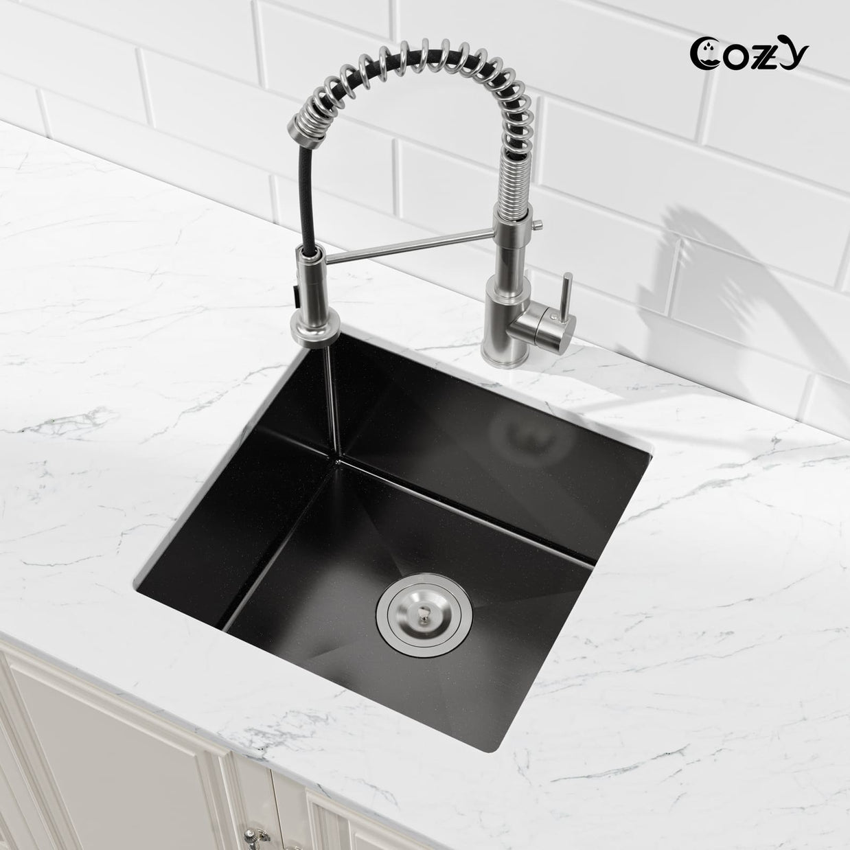 Angled view of Cozy 18-inch matte black undermount single bowl handmade kitchen sink installed on white marble countertop