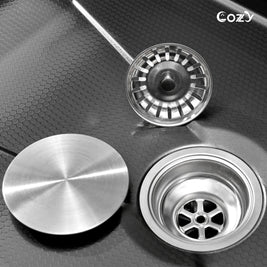 Close-up of Cozy 30-inch black drop-in single bowl workstation kitchen sink featuring stainless steel drain assembly, removable basket strainer, and cover lid