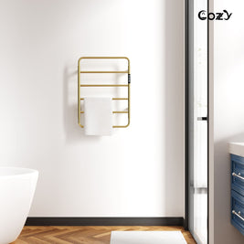 Cozy EB01 electric heated towel rack in brushed gold installed in a modern bathroom.