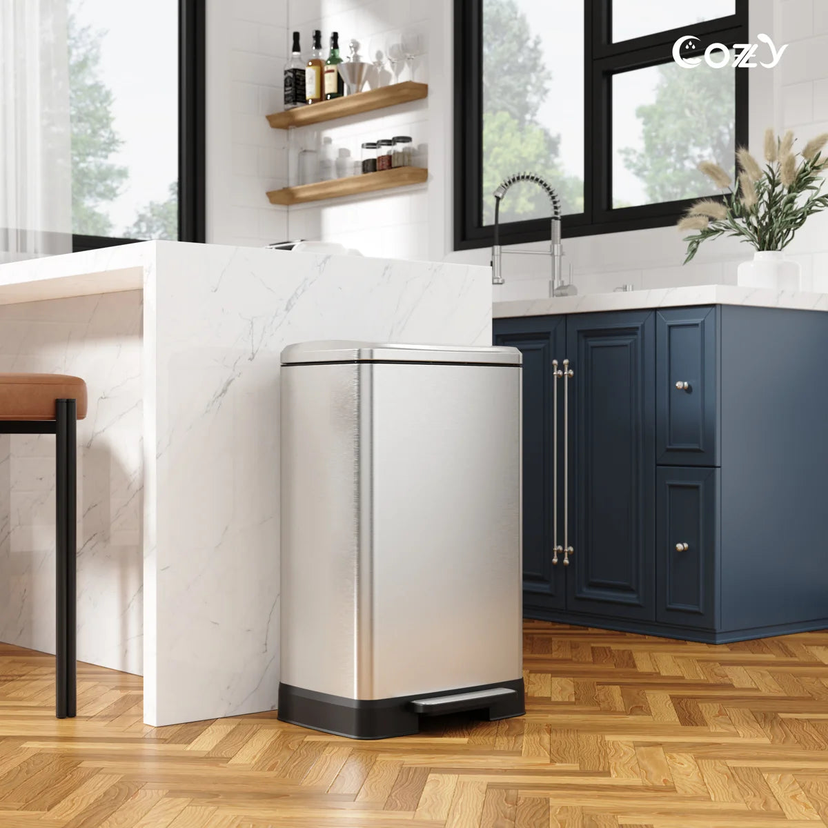 Cozy TC01-14 brushed stainless 14.5-gallon pedal trash can placed beside a kitchen island.